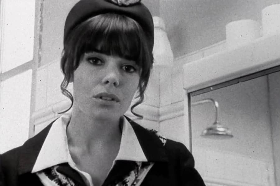 a woman in a flight attendant uniform looks at the camera