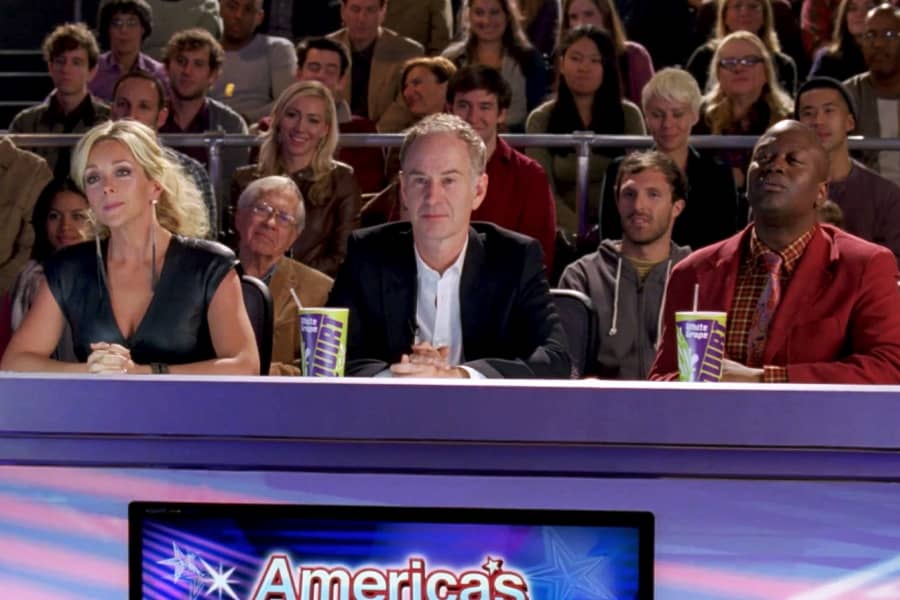 a judge’s table with Jenna Maroney, John McEnroe, and D’Fwan