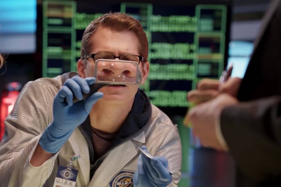 another scientist looks into a magnifying glass