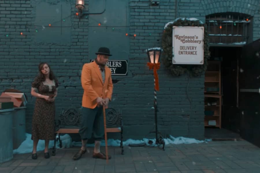 Heathstead and Beatrix stand outside the cobblery looking away from each other