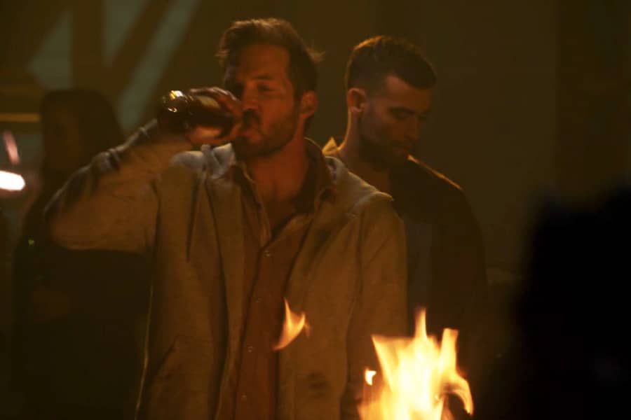 Casablancas drinking from a bottle by the fire