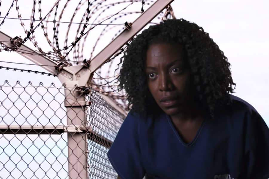 inmate confessional interview with fence and razor wire backdrop