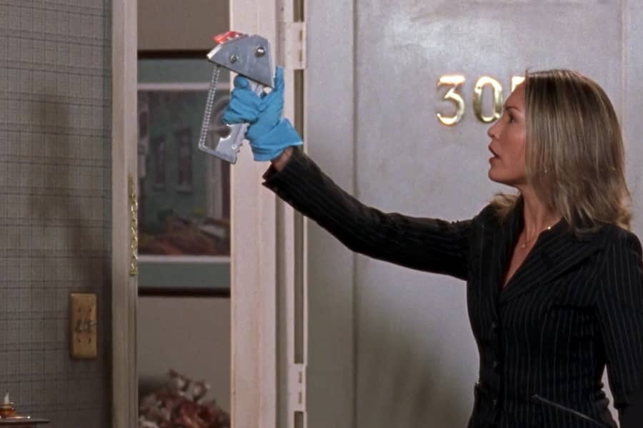 a female investigator scans the wall of a crime scene with a handheld device