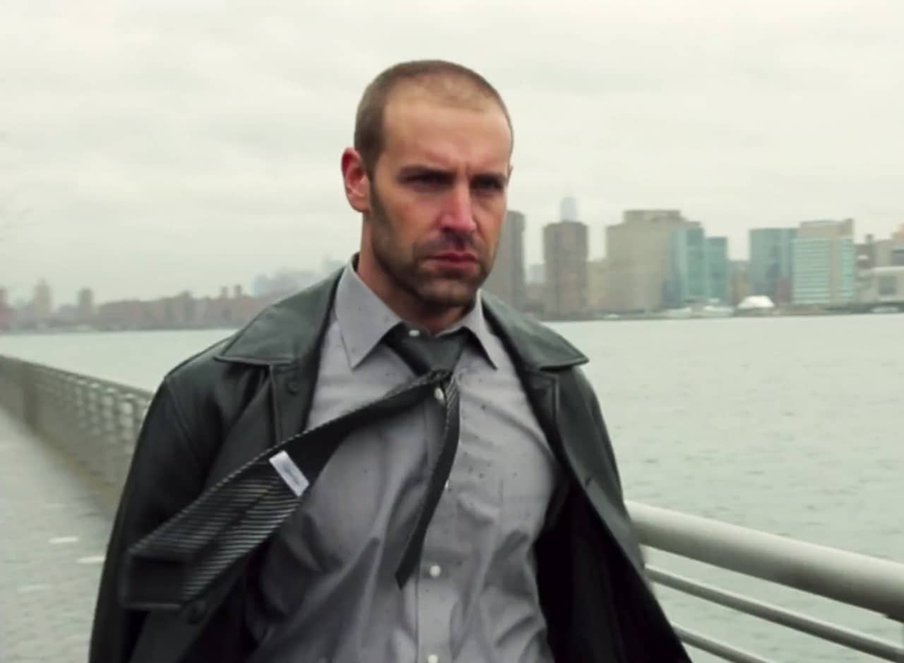 Charlie Pollock walks across a bridge with the city in the background