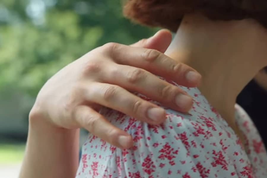 the man places his hand gently on the woman’s shoulder