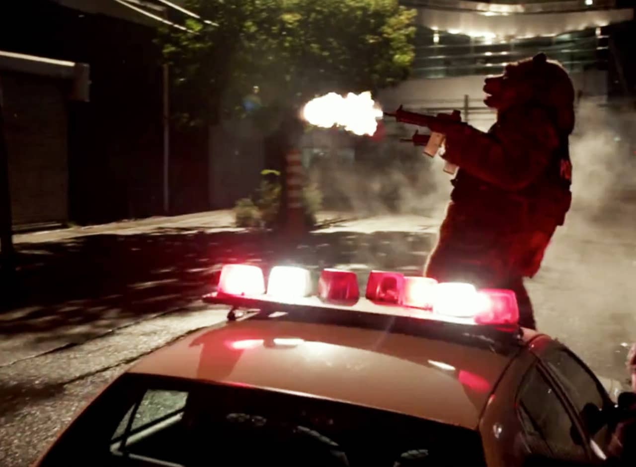 Hammy the Bear stands on a cop car firing two machine guns