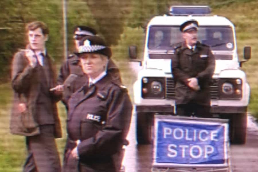 cops and a reporter stand by a police stop