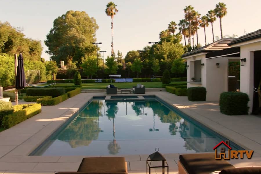 a fancy backyard with pool and basketball court