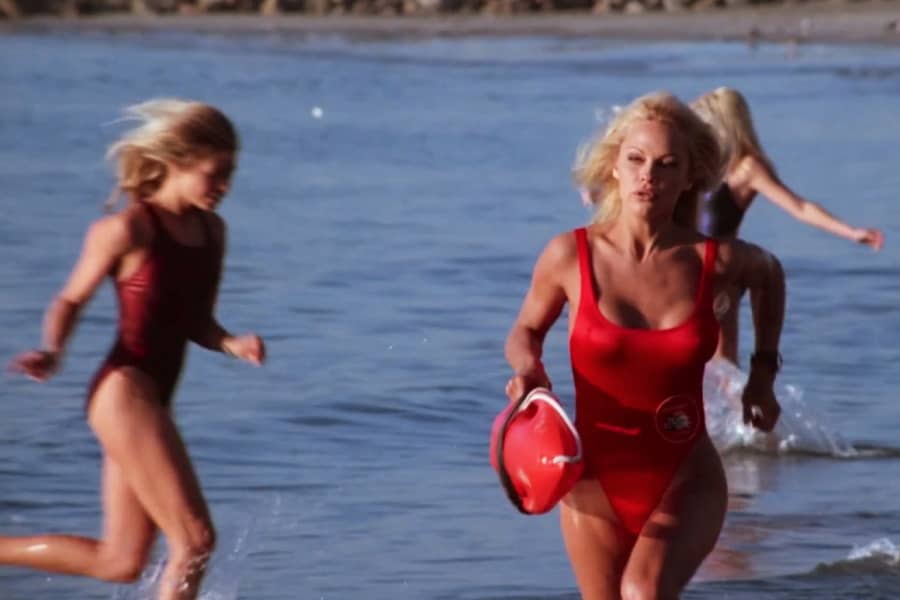 another beautiful lifeguard runs on the beach