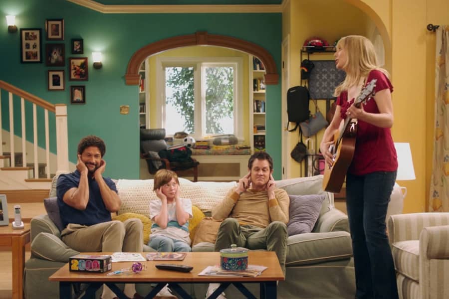 the family covering their ears while Josie plays the guitar