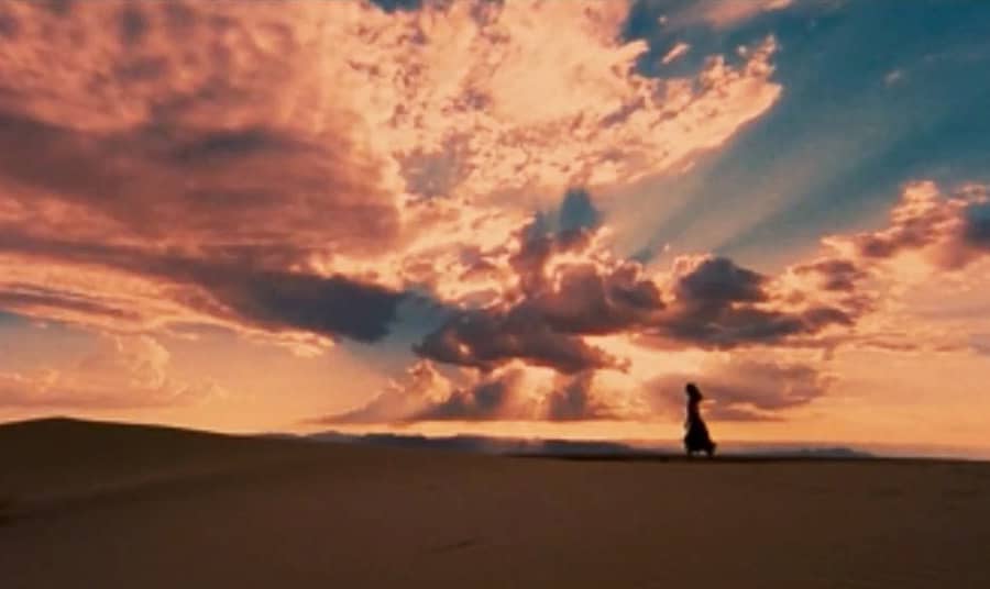 Teresa’s sillouhette walking in the desert against a beautiful clouded sky