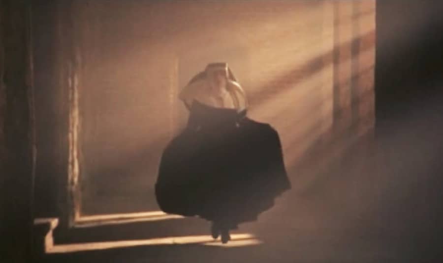 Teresa running a church corridor as light streams in through the windows