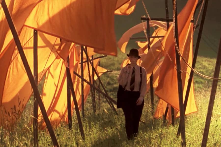 a woman in a suit walks between hanging laundry, a romantic scene