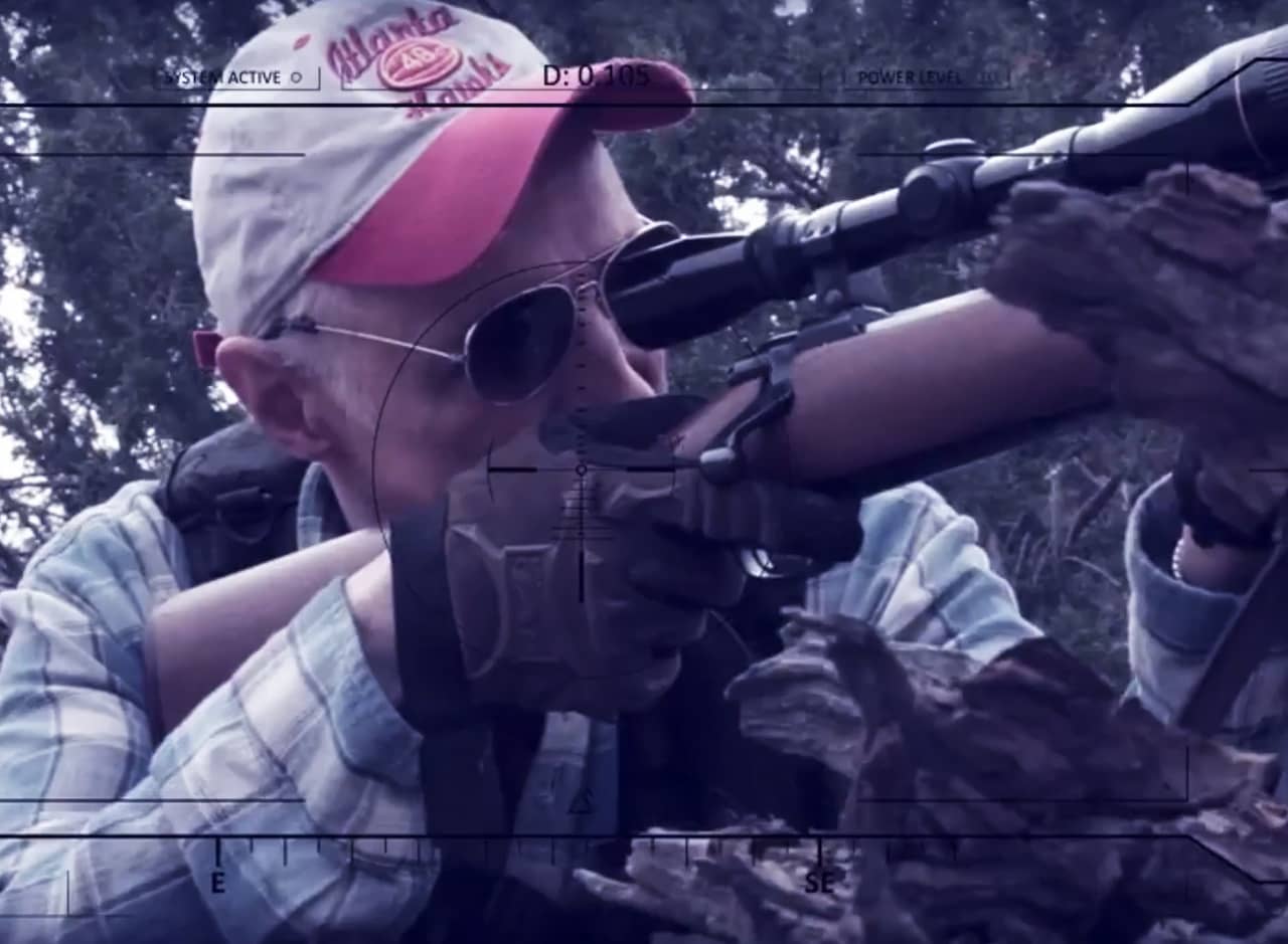 Burt Gummer looks into the scope of a gun