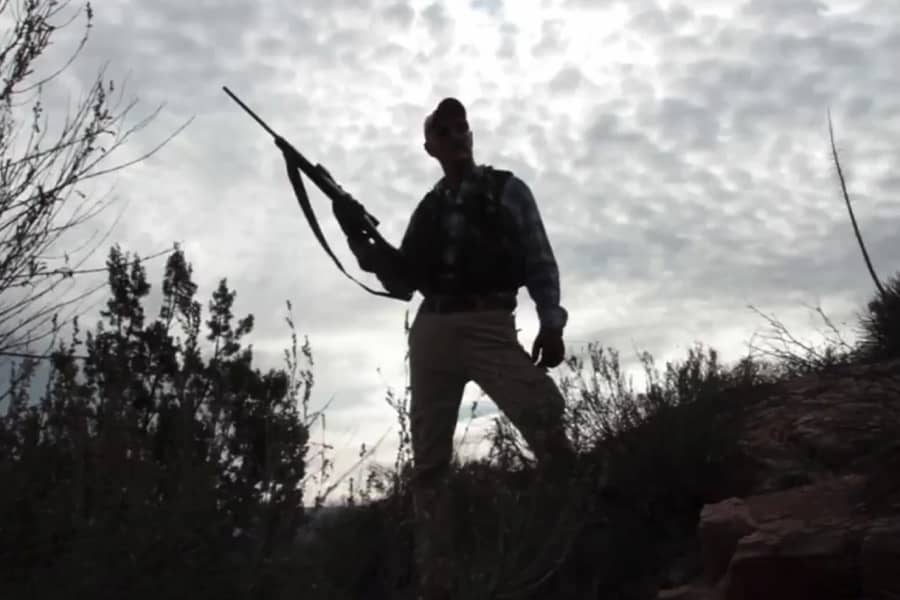 Gummer’s silhouette holding a gun in the desert