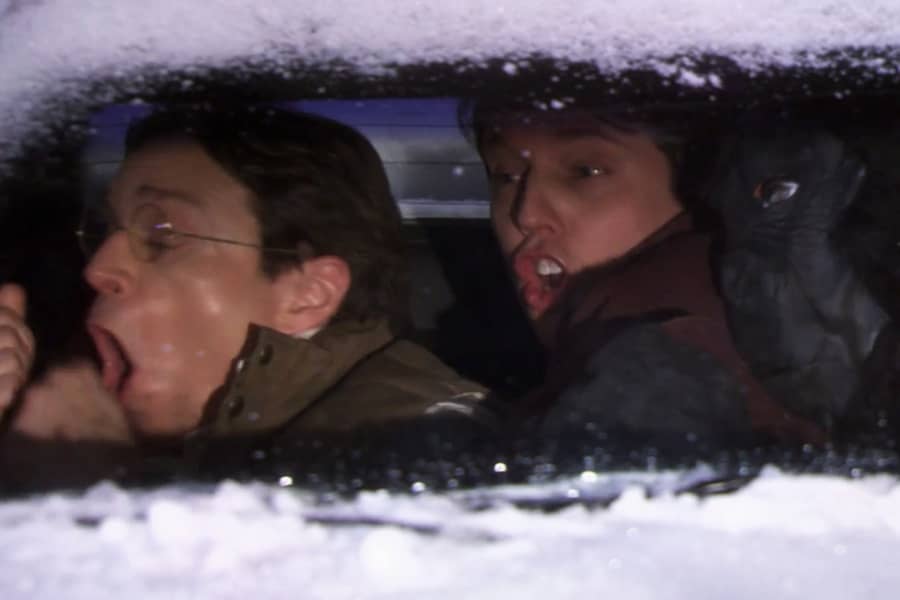 Jed and Narshall cuddle a snow-covered car