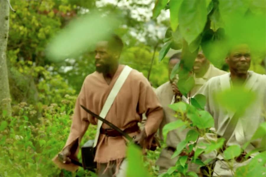 Haitian men walk through the jungle